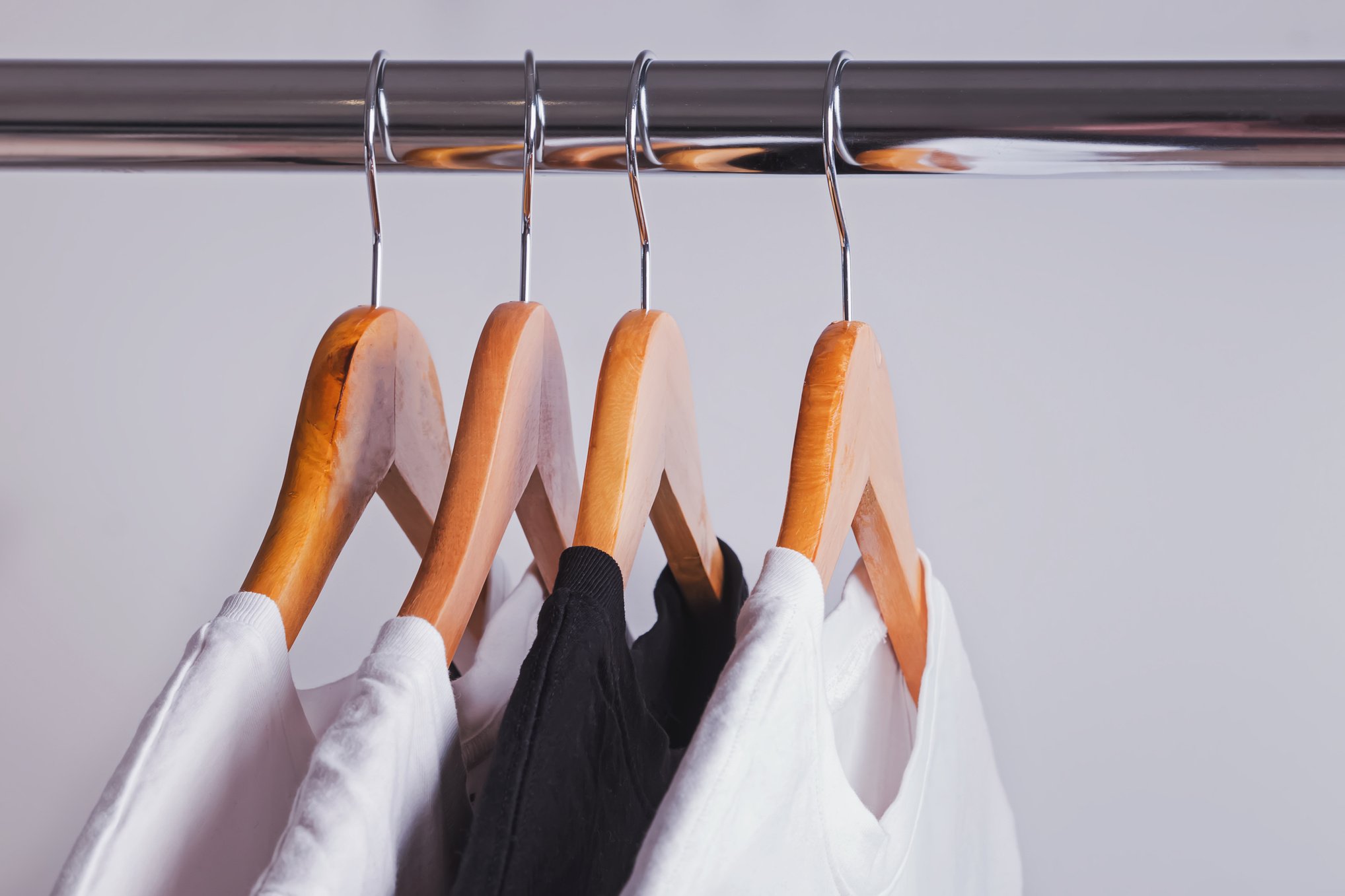 One Black T-Shirt in a Row of White Shirts Hanging